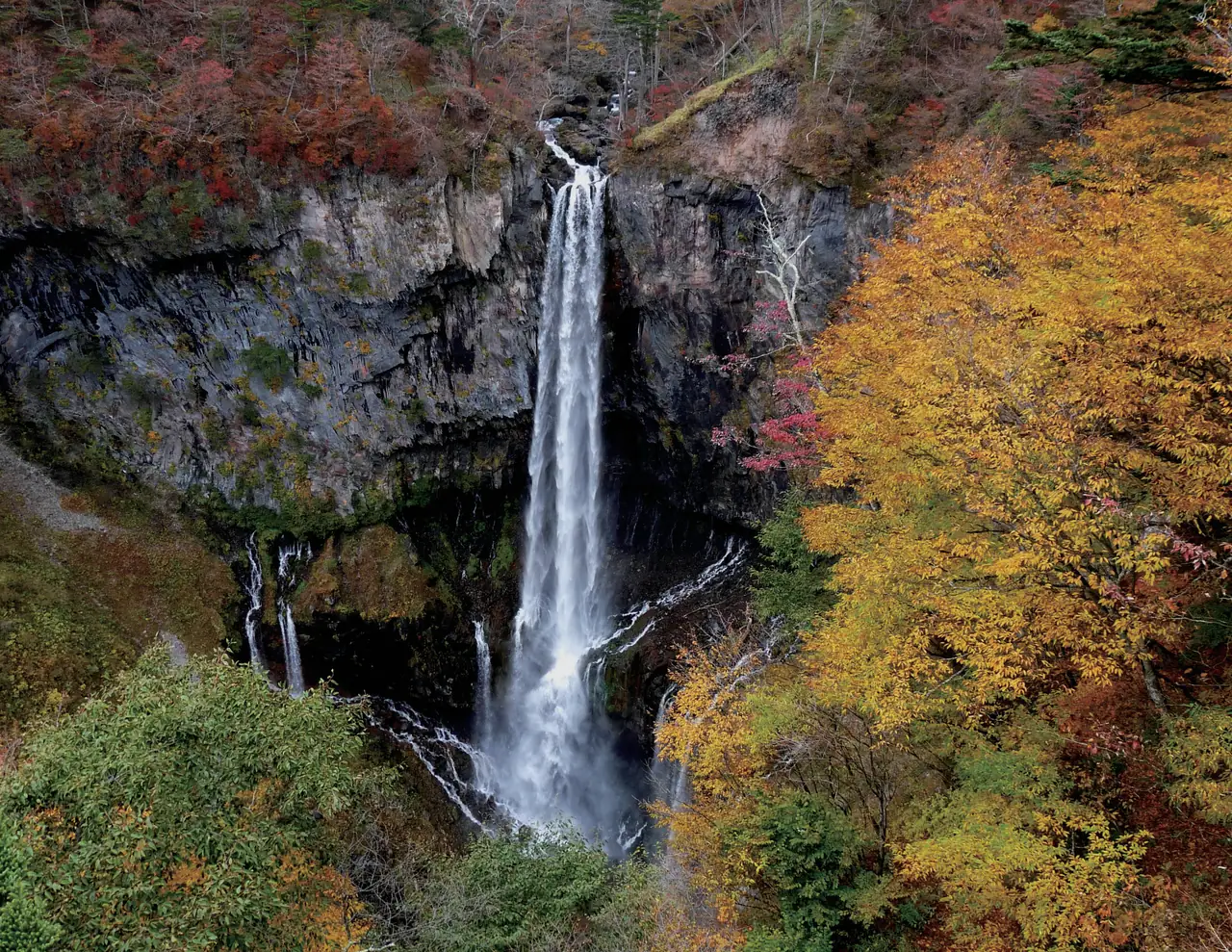 紅葉した木々に囲まれた断崖を、一筋に流れ落ちる華厳の滝