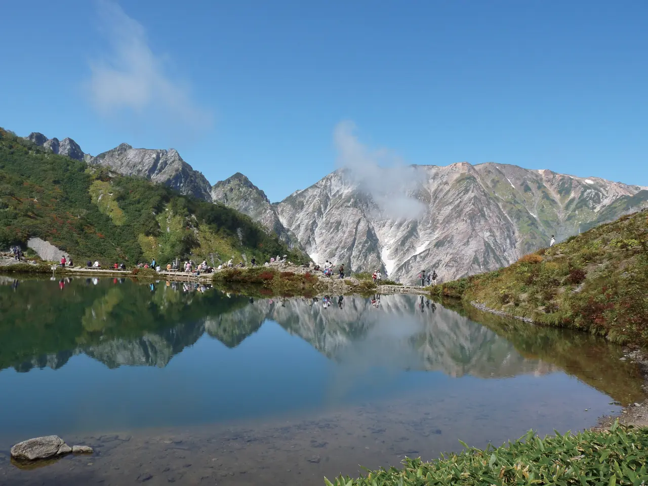 雪の残る白馬の山並みが、八方池の水面に鏡のように映る
